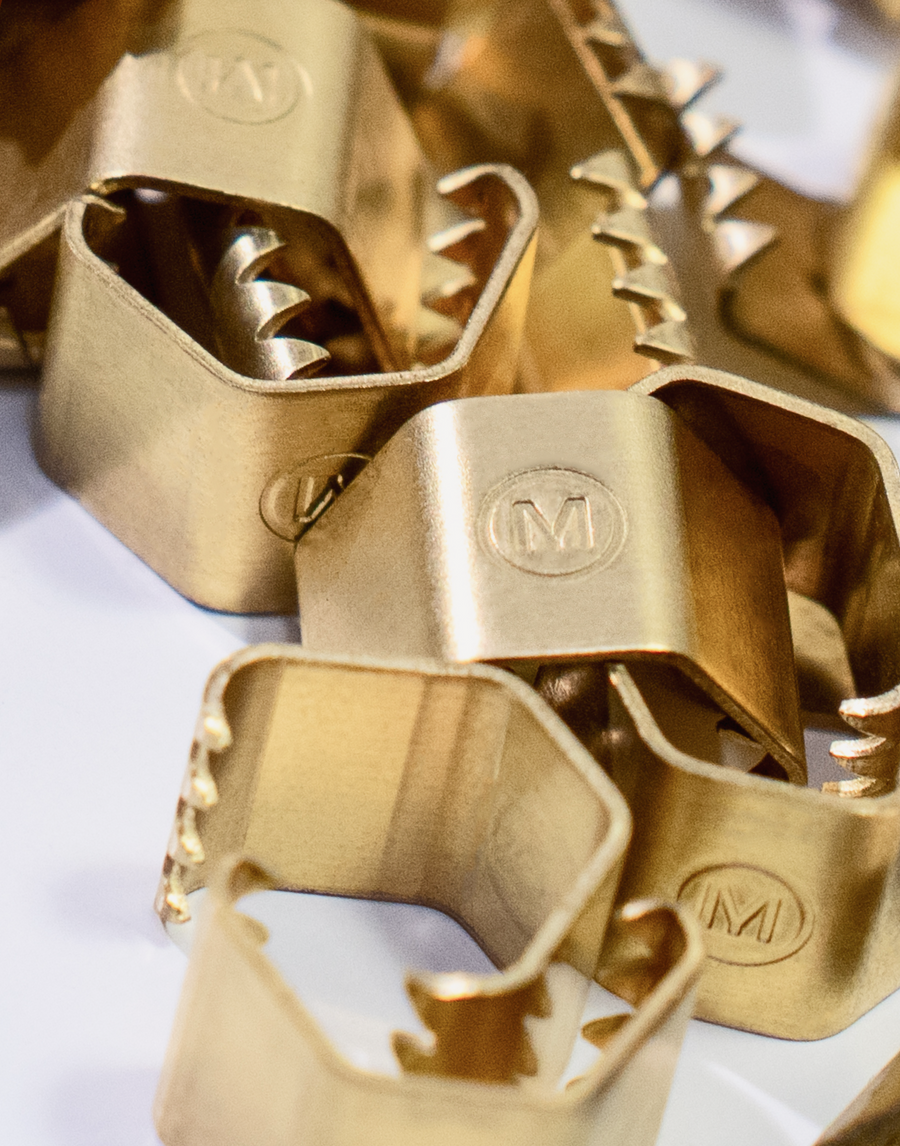 Close up detail of MANTLE® branded connection clamps in solid brass