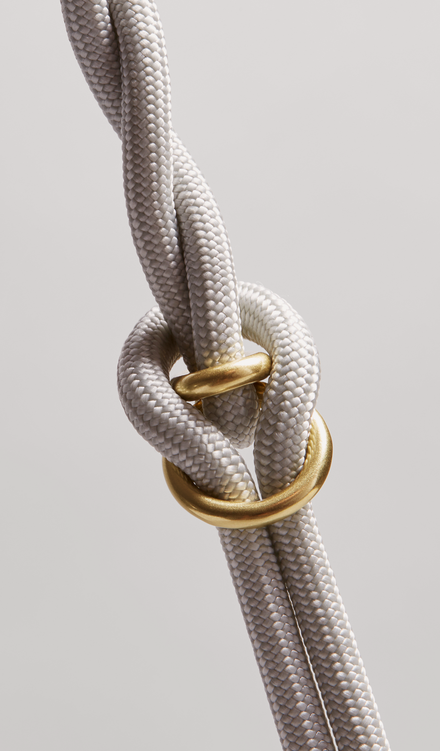 MANTLE® dog system handle attachment in Haze with solid brass hardware, shown from an overhead view on a light gray background