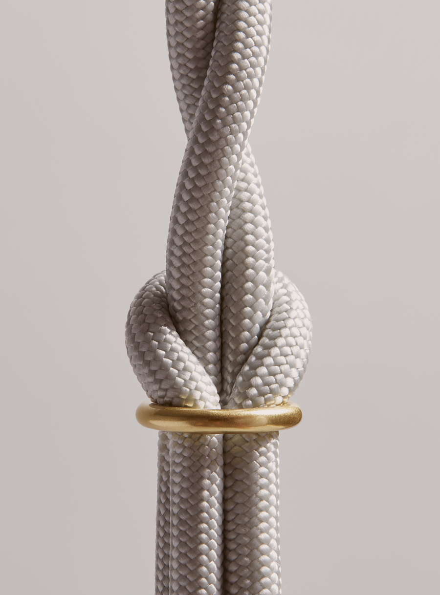 Close up of MANTLE® dog leash in HAZE with solid brass hardware on a light gray background